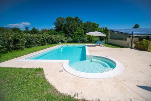 a swimming pool in a yard next to a house at Agriturismo Turina in Bricherasio