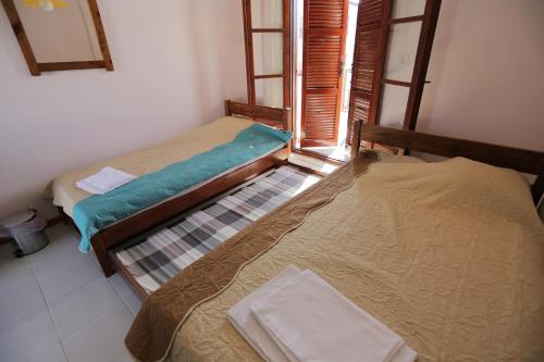 twee eenpersoonsbedden in een kamer met een raam bij House Nativa in Mola Kalyva