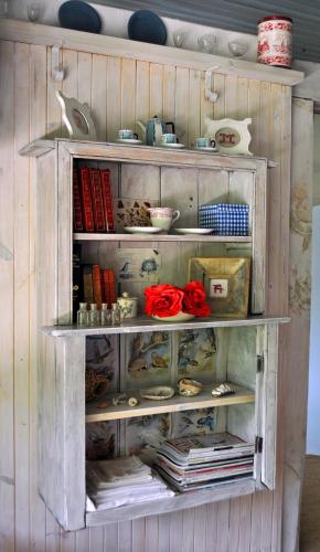 a wooden shelf with dishes and books on it at Cleopatra Mountain Farmhouse in Fort Nottingham