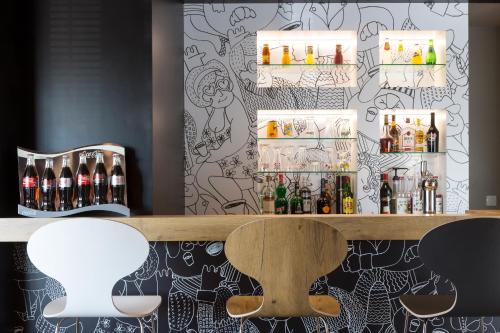 a bar with a counter with bottles of alcohol at ibis Lorient Centre Hôtelier in Caudan