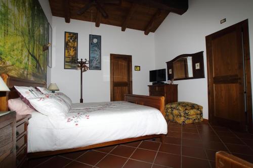 a bedroom with a white bed and a chair at Casale Farnesiana B&B in Tarquinia