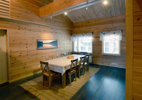 a dining room with a table and chairs in a cabin at Kiiruna Kitkankieppi in Virrankylä