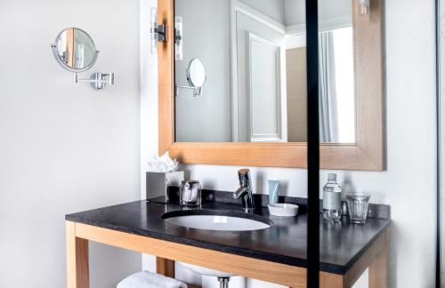 a bathroom with a sink, mirror, and a towel rack at Pillows Grand Boutique Hotel Reylof Ghent in Ghent
