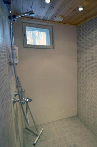a shower in a bathroom with a window at Kiiruna Kitkankieppi in Virrankylä