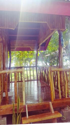 a view of a wooden porch with the sun shining at White Beach Front and Cottages in Buruanga
