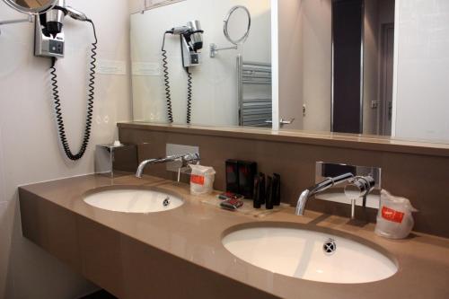 ein Badezimmer mit 2 Waschbecken und einem Spiegel in der Unterkunft Chambellan Morgane in Paris