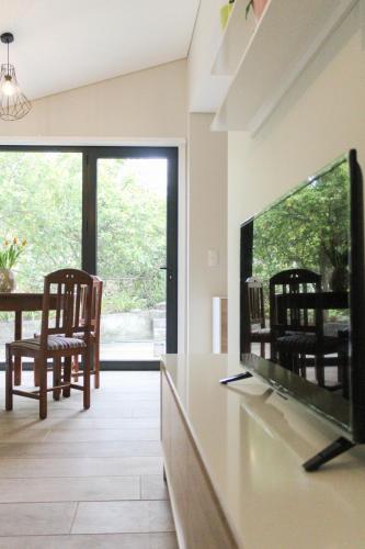 a living room with a tv and a table and chairs at Garden House Ramalde in Porto