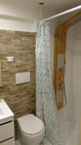 a bathroom with a toilet and a shower curtain at Vera Vacanza in Sannicola
