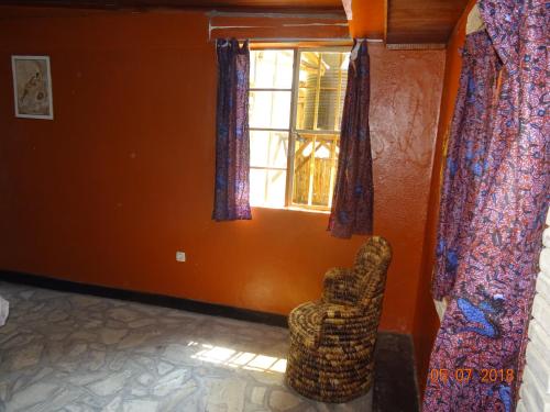 a living room with a chair and a window at Kivu Beach Garden in Gisenyi