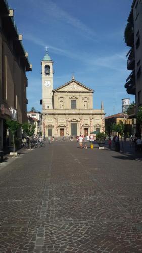 a building with a clock tower in the middle of a street at B&B Honey Rooms in Saronno