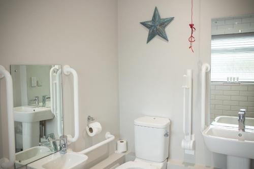 a white bathroom with a toilet and a sink at George Hotel, BW Signature Collection in Norwich