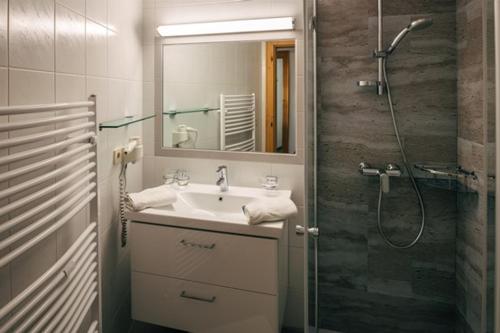 a bathroom with a sink and a shower with a mirror at Appartement Fossa in Fiss