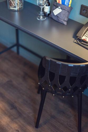 a black desk with a black chair under it at Best Western Plus Hus 57 in Ängelholm