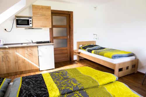 Habitación pequeña con 2 camas y cocina en Penzion Starobor, en Sedlice