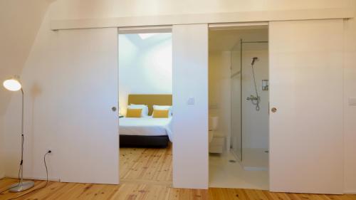 a bedroom with a bed and a shower in a room at Apartamentos Premium Familiares - Loft Guesthouse BeMyGuest Viseu in Viseu