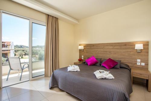 a bedroom with a large bed with pink pillows at Evita in Faliraki