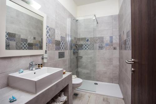 a bathroom with a sink and a toilet and a shower at Evita in Faliraki