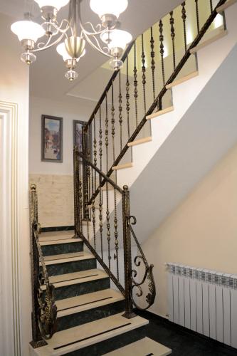 a staircase in a home with a chandelier at Hotel Nicolas in Tbilisi City