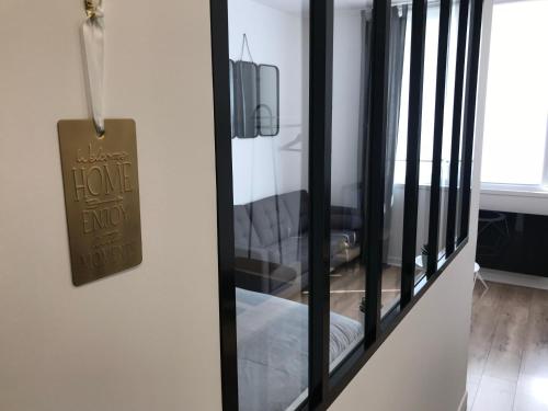 a glass door with a home exit sign on it at Au Studio 36 Arras avec parking privé in Arras