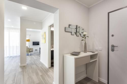 a white living room with a vase on a table at Luxury Beach Apartment at Armação de Pêra in Armação de Pêra