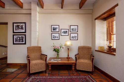 a living room with a table and two chairs at De Hoek Manor in Stellenbosch