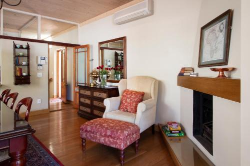 a living room with a chair and a mirror at De Hoek Manor in Stellenbosch