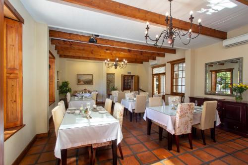 a dining room with tables and chairs and a chandelier at De Hoek Manor in Stellenbosch