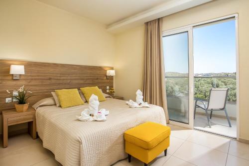 a hotel room with a bed and a large window at Evita in Faliraki
