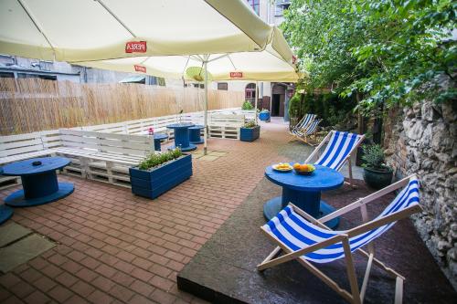 een terras met stoelen, een tafel en een parasol bij Let's Rock Party Hostel! Age Limit From 18 until 40! in Krakau