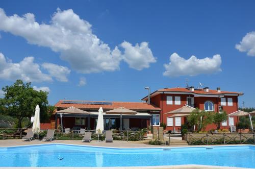 a resort with a swimming pool and a building at Il Podere di Marfisa in Farnese