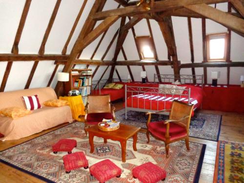a living room with a bed and chairs in a attic at Château d'Avanton in Avanton