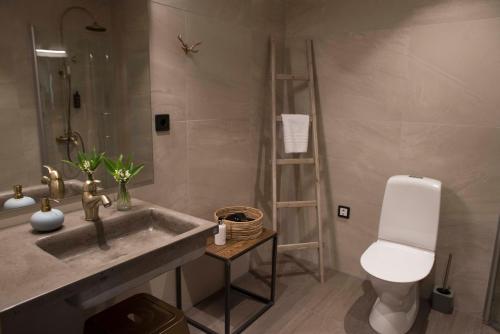 a bathroom with a sink and a toilet at Toftastrand Hotell in Växjö