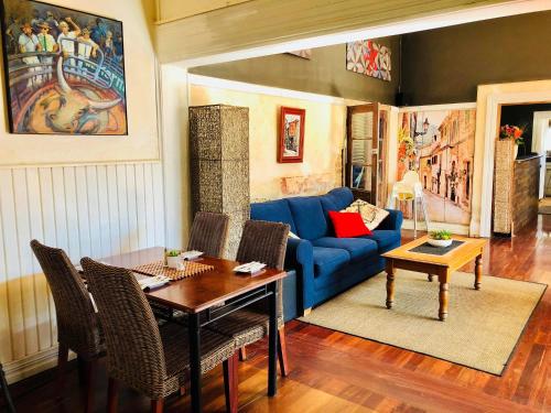 Una sala de estar con un sofá azul y una mesa. en Junction Hotel Moora, en Moora