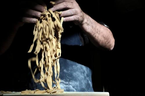 a person holding a pile of pasta in their hand at Relais La Torre in Chiassa Superiore