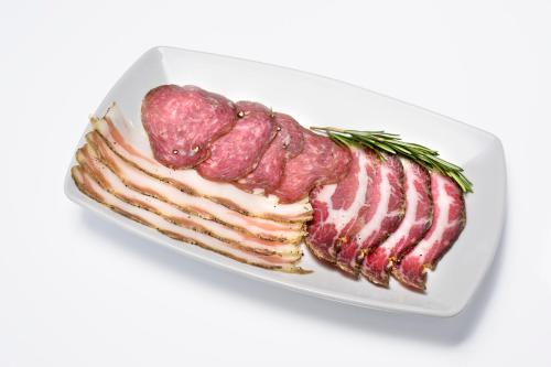 a white plate with bacon and rosemary on it at Relais La Torre in Chiassa Superiore
