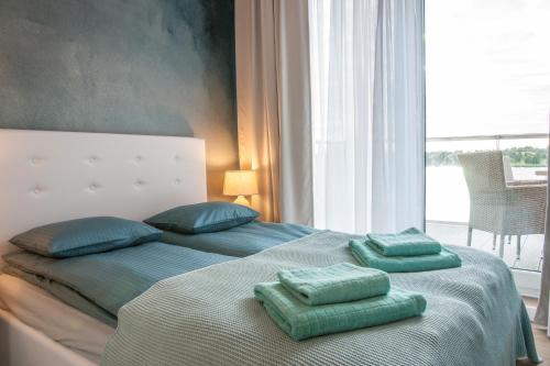 a bedroom with a bed with two green pillows on it at Apartament Villa Nautica in Rydzewo