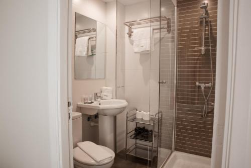 y baño con aseo, lavabo y ducha. en Hotel Feliz, en Palma de Mallorca