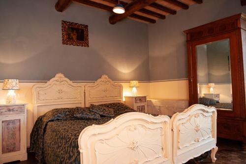 a bedroom with a white bed and a mirror at La casina di Giannetto in Seggiano