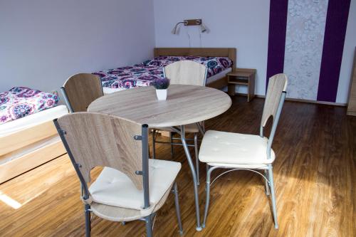 a room with a table and chairs and a bed at Penzion Starobor in Sedlice