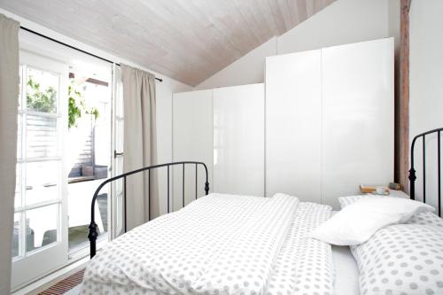 een witte slaapkamer met 2 bedden en een raam bij Ubytování v Renesančním domě in Mikulov