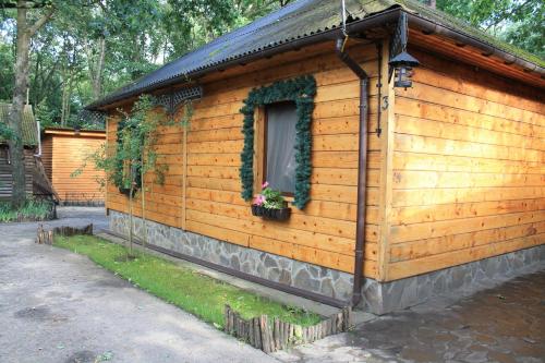 a wooden cabin with a window and plants on it at Dikii Med in Geletintsy