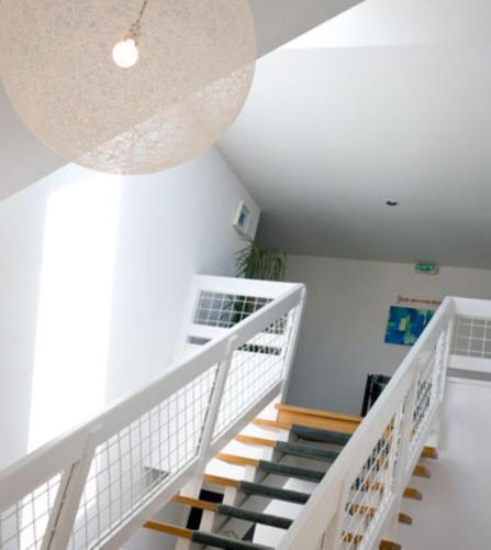 a staircase in a house with a white stair case at Hotel le Crouesty in Arzon