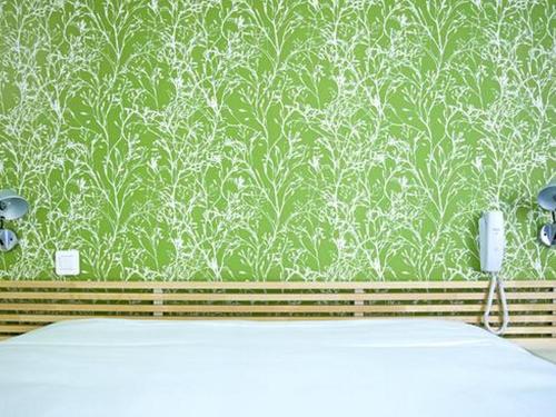 a bathroom with a green and white wallpaper and a phone at Hotel le Crouesty in Arzon