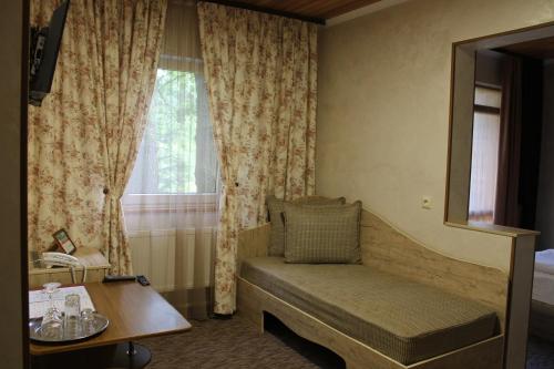 a small room with a couch and a window at Dikii Med in Geletintsy