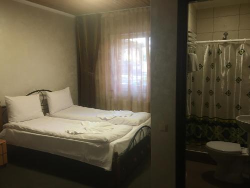 - une petite chambre avec un lit et un lavabo dans l'établissement Dikii Med, à Geletintsy