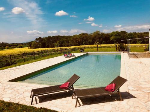 a swimming pool with two lounge chairs next to it at B&B El Ranxo in Franciach