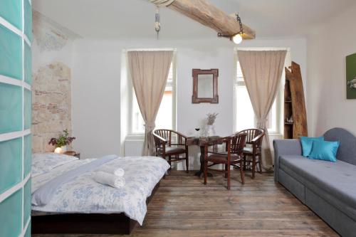 a living room with a bed and a table and chairs at Pension Sebastian in Mikulov