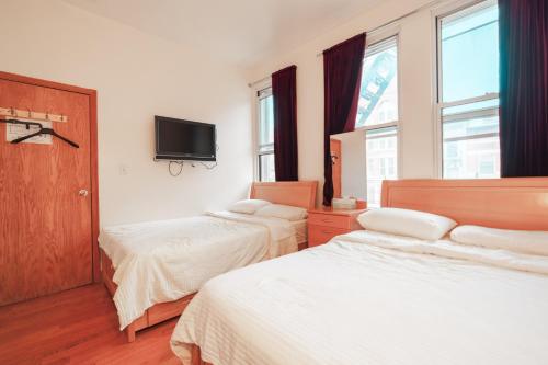 a bedroom with two beds and a tv on the wall at U.S. Pacific Hotel in New York