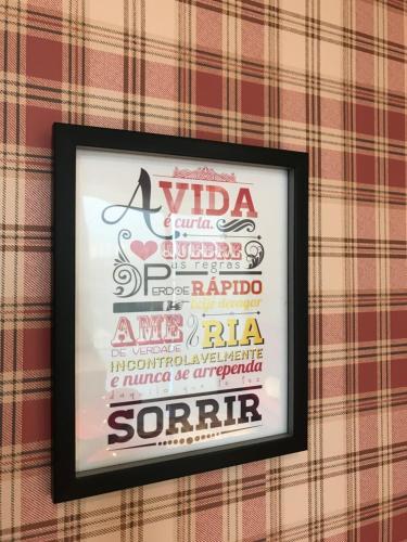 a framed picture of a vida sign on a wall at Anitta 2 in Sao Paulo