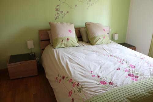 - un lit avec des draps blancs et des fleurs roses dans l'établissement Charmante maison de village, à Cucuron